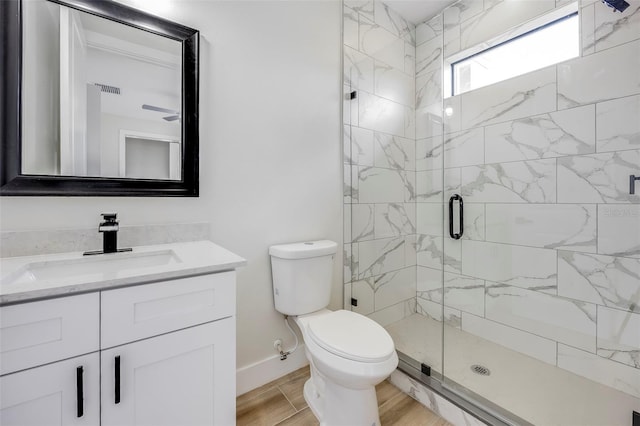 bathroom featuring vanity, a shower with shower door, and toilet