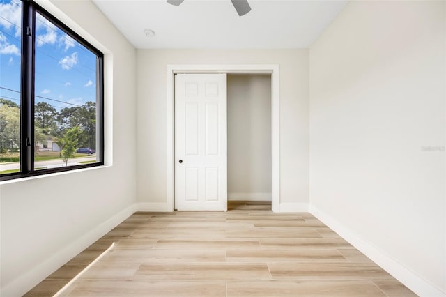 unfurnished bedroom featuring a closet, light hardwood / wood-style floors, and ceiling fan