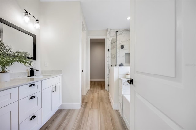 bathroom with hardwood / wood-style flooring, vanity, and independent shower and bath