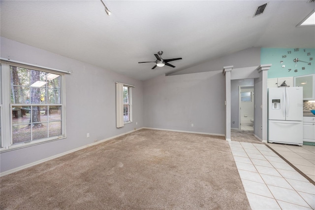 interior space with a wealth of natural light, light tile patterned floors, lofted ceiling, and ceiling fan