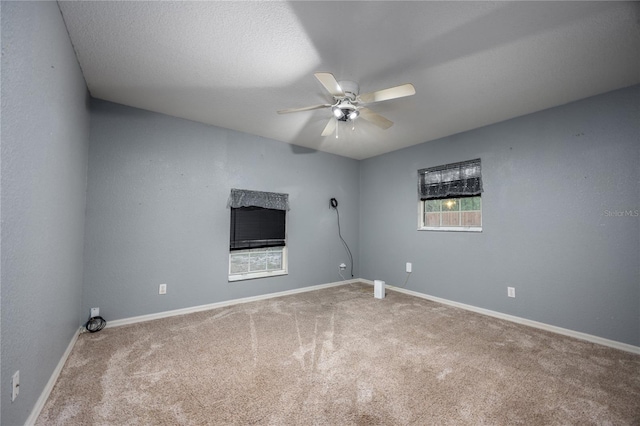 carpeted spare room featuring ceiling fan and a textured ceiling