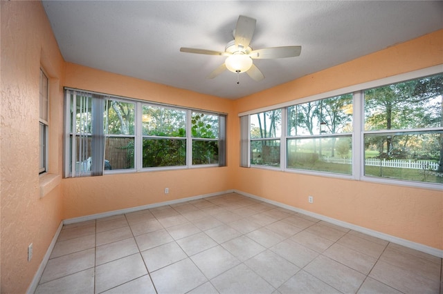 unfurnished sunroom featuring ceiling fan