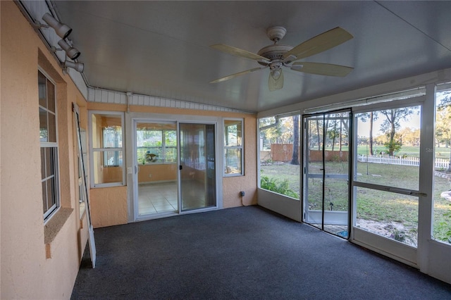 unfurnished sunroom with a wealth of natural light, lofted ceiling, and ceiling fan