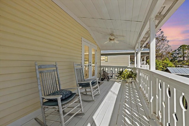 deck at dusk with ceiling fan and french doors