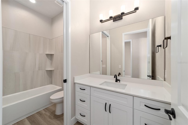 full bathroom featuring hardwood / wood-style floors, vanity, toilet, and shower / washtub combination