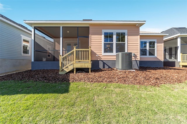 back of house featuring a sunroom, cooling unit, and a yard