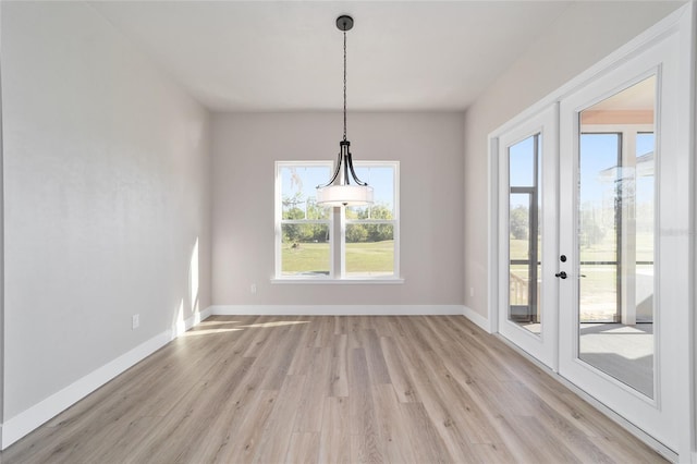 unfurnished dining area featuring french doors and light wood-type flooring