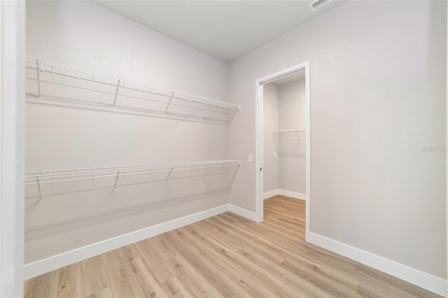 spacious closet with light hardwood / wood-style floors