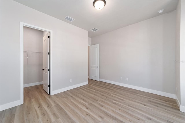 1069 NW 132nd Blvd, Newberry, FL 32669 - unfurnished bedroom featuring light wood-type flooring, baseboards, a walk in closet, and a closet