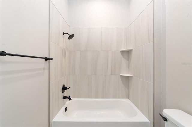 bathroom featuring tiled shower / bath combo and toilet