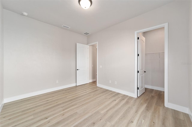 1069 NW 132nd Blvd, Newberry, FL 32669 - unfurnished bedroom with light wood finished floors, baseboards, a spacious closet, and a closet