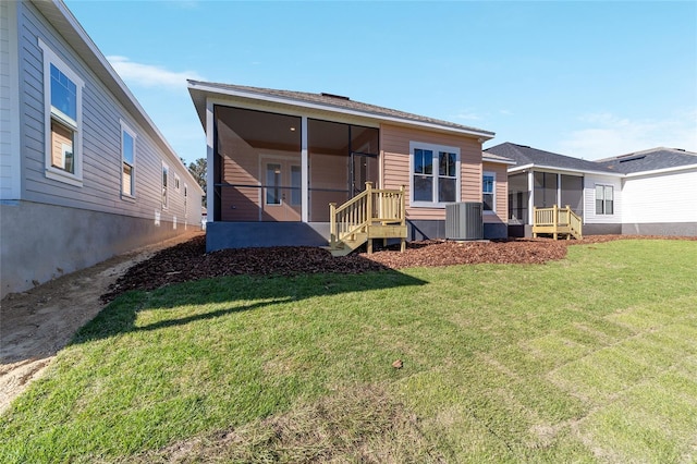 back of house with a lawn, a sunroom, and central AC unit