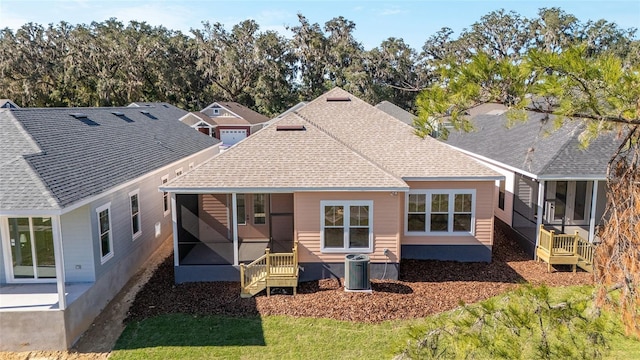 rear view of house featuring a sunroom and central AC