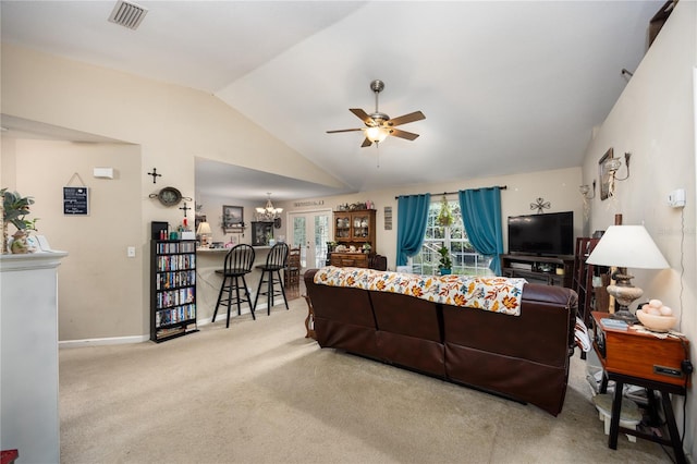 carpeted living room featuring french doors, ceiling fan with notable chandelier, and vaulted ceiling