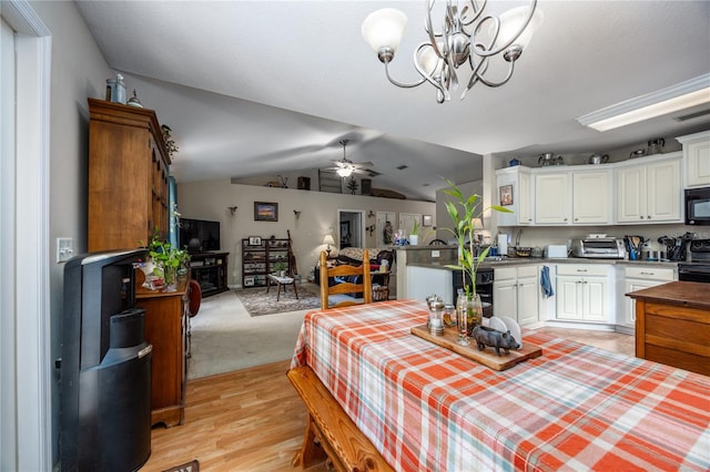 dining area with light wood-type flooring, ceiling fan with notable chandelier, beverage cooler, and lofted ceiling