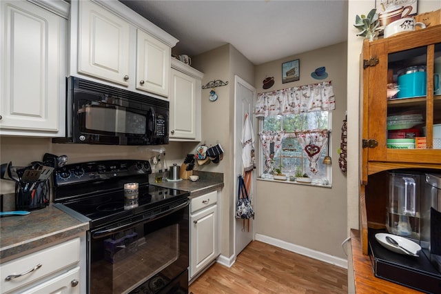 kitchen with light hardwood / wood-style flooring, white cabinets, and black appliances