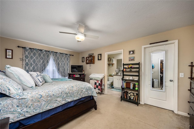 carpeted bedroom featuring a textured ceiling, ensuite bathroom, and ceiling fan