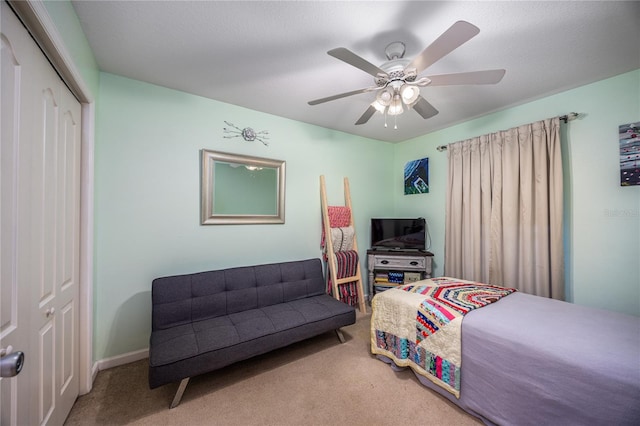 carpeted bedroom with ceiling fan, a closet, and a textured ceiling