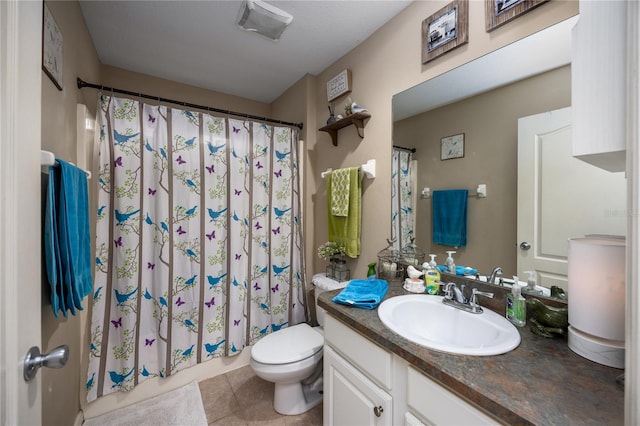 bathroom with toilet, vanity, and tile patterned floors