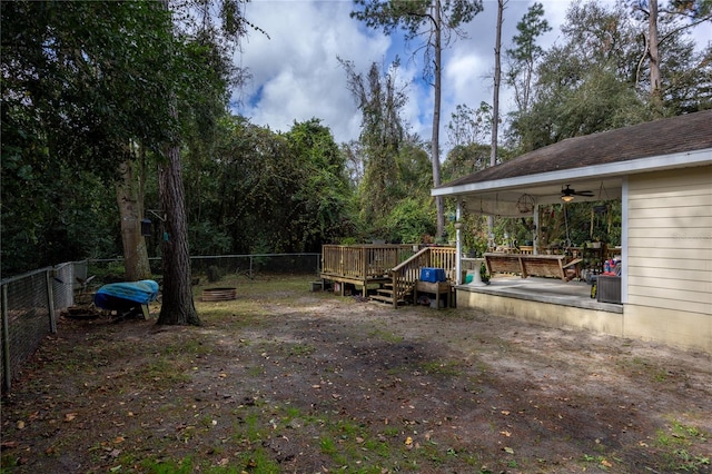 view of yard with a deck and ceiling fan