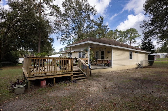 rear view of house featuring ceiling fan and a deck