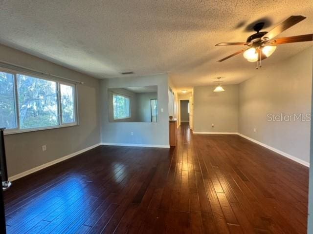 unfurnished room featuring a textured ceiling, dark hardwood / wood-style flooring, and ceiling fan