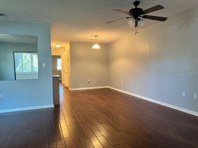 unfurnished room with a textured ceiling, dark hardwood / wood-style floors, and ceiling fan