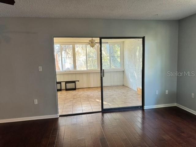 spare room featuring ceiling fan, wood-type flooring, and a textured ceiling