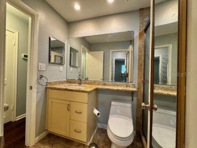 bathroom with vanity, hardwood / wood-style flooring, and toilet