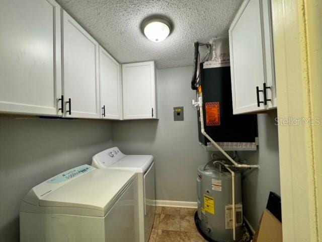 washroom featuring cabinets, independent washer and dryer, electric water heater, and a textured ceiling