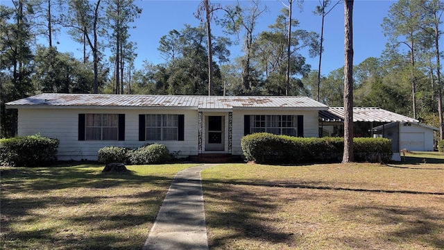 view of front of house featuring a front yard, a garage, and an outdoor structure