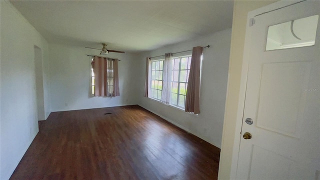 unfurnished room featuring ceiling fan and dark wood-type flooring