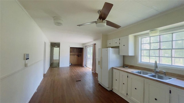 kitchen with ornamental molding, dark wood-type flooring, sink, white cabinets, and white fridge with ice dispenser