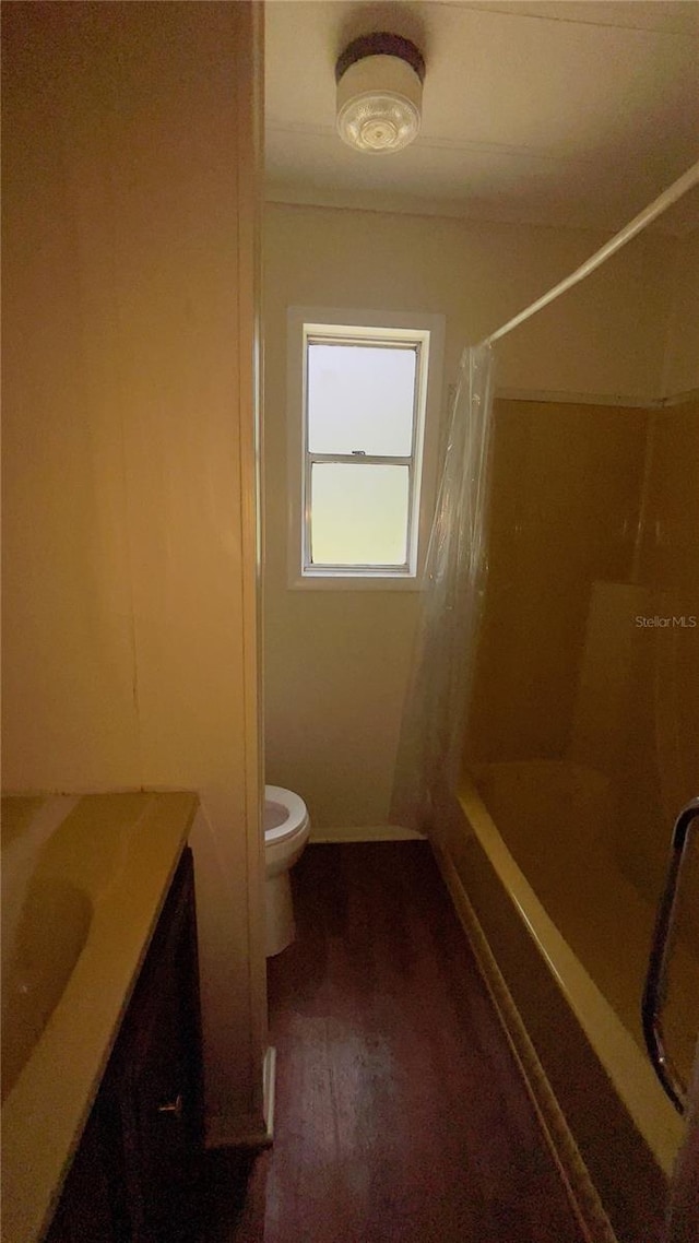 full bathroom featuring vanity, wood-type flooring, shower / tub combo, and toilet