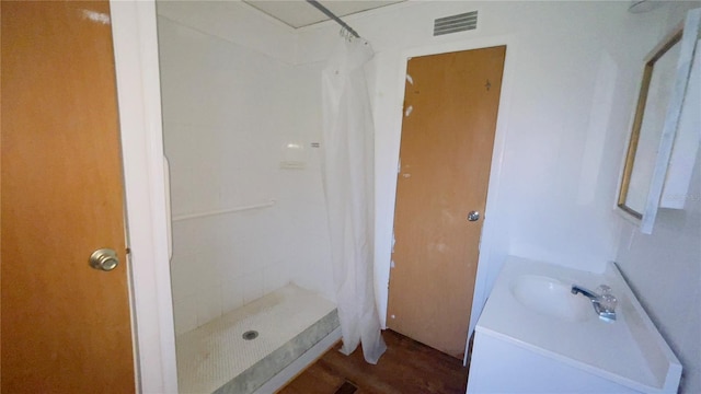 bathroom featuring hardwood / wood-style floors, vanity, and curtained shower