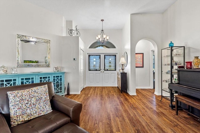 entryway featuring hardwood / wood-style floors, a towering ceiling, and a chandelier