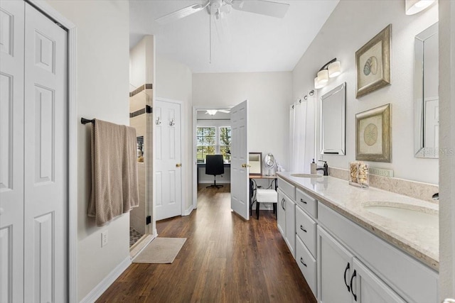 bathroom featuring hardwood / wood-style flooring, ceiling fan, walk in shower, and vanity