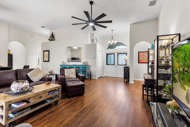 living room with ceiling fan with notable chandelier, high vaulted ceiling, and dark wood-type flooring