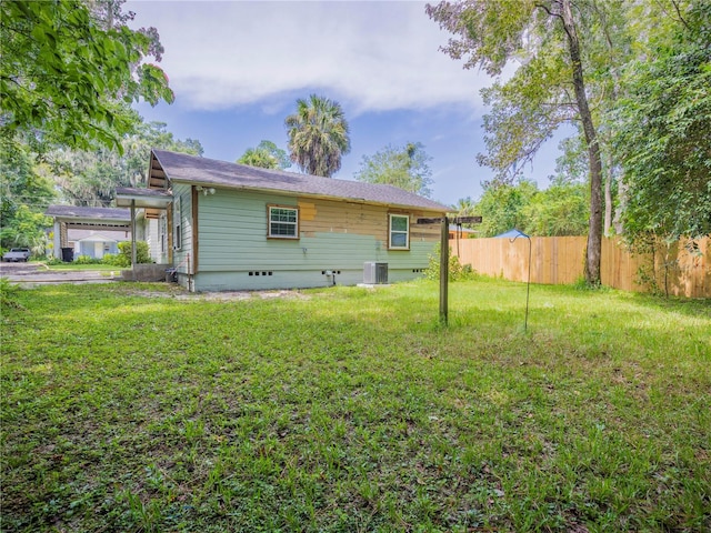 rear view of house featuring a lawn and cooling unit