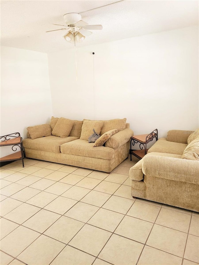 living room featuring light tile patterned floors, a textured ceiling, and ceiling fan