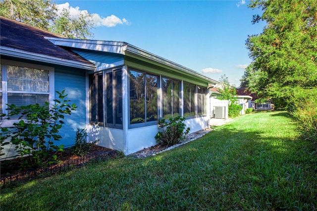 view of property exterior featuring a sunroom and a lawn