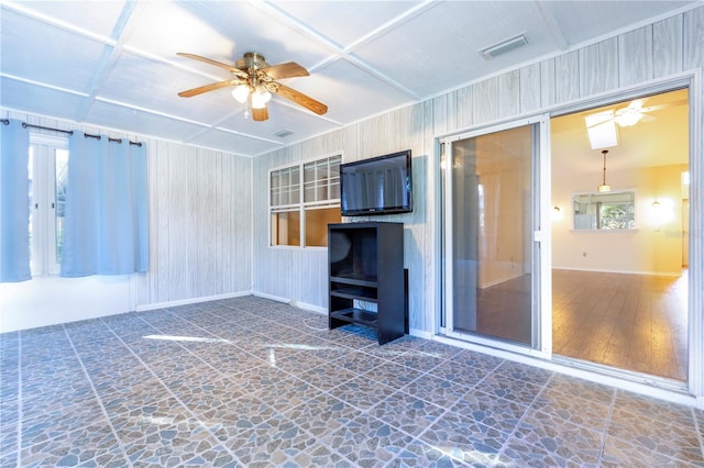 unfurnished living room with coffered ceiling, ceiling fan, wooden walls, and dark hardwood / wood-style floors