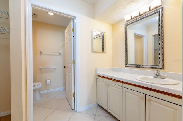 bathroom with tile patterned flooring, vanity, and toilet