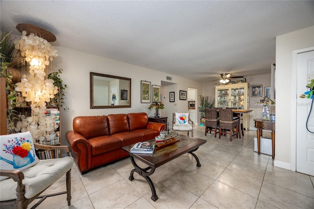 tiled living room featuring a textured ceiling and ceiling fan