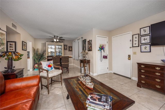 living room with light tile patterned floors, a textured ceiling, and ceiling fan