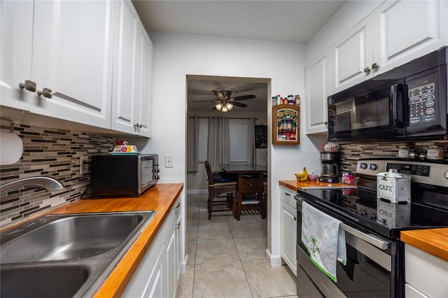 kitchen with wood counters, white cabinetry, and stainless steel appliances