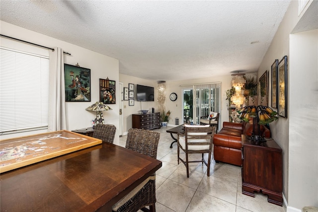 dining area featuring light tile patterned flooring and a textured ceiling