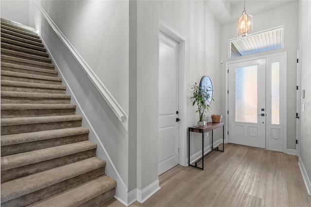 11903 SW 31st Rd, Gainesville, FL 32608 - foyer with stairway, light wood-type flooring, a chandelier, and baseboards