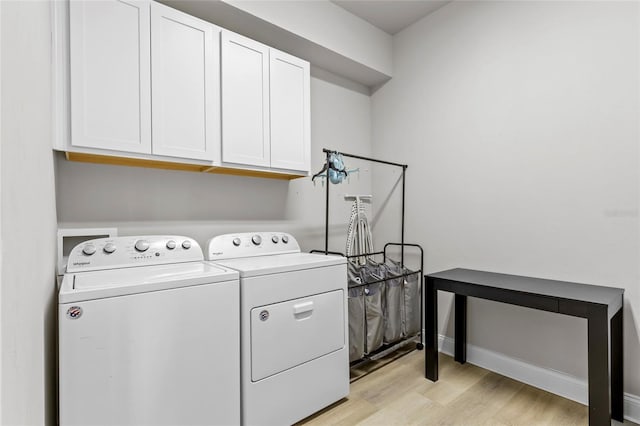 laundry area featuring light hardwood / wood-style flooring, cabinets, and independent washer and dryer