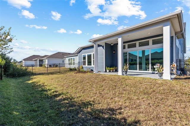 back of property with a patio area and a lawn